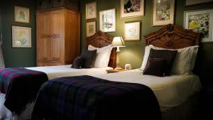 温彻斯特阿尔弗雷德国王酒店的卧室设有两张床铺和绿色的墙壁