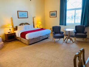 亚历山德里亚贝里维雷奇度假酒店的一间卧室配有一张床、两把椅子和一张桌子