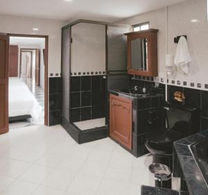 佩雷拉NOGAL HOSTEL的一间带水槽和淋浴的浴室以及一张床