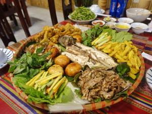 宁平Trang An Lotus Lake Homestay的桌子上一盘肉和蔬菜
