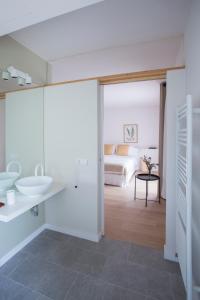 TivissaHotel Rural Mas de l'Illa的一间带水槽的浴室和一张位于客房内的床