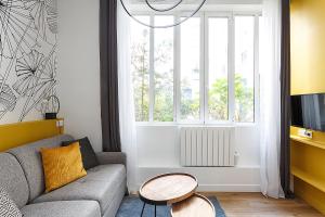 巴黎Superb Mini Loft close Montmartre 2 people的带沙发、桌子和窗户的客厅