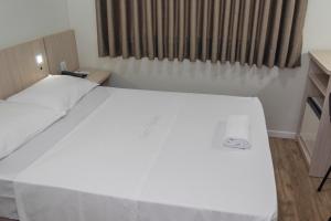 伊达贾伊Hotel Vitoria - Itajaí的窗户客房内的一张大白色床
