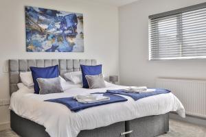 谢菲尔德Modern, Cosy & Convenient 3 bed 2 bath House WiFi Parking by Ark SA的一间卧室配有一张带蓝色枕头的大床