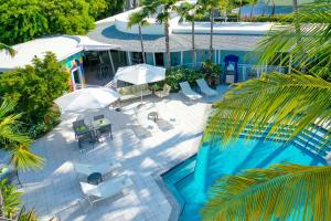 基韦斯特Orchid Key Inn - Adults Only的享有带椅子和遮阳伞的游泳池的上方景致