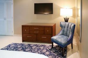基韦斯特Orchid Key Inn - Adults Only的一间卧室配有椅子和带电视的梳妆台