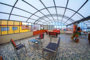 普诺Inka's Rest Hostel的一个带桌椅的庭院和玻璃屋顶