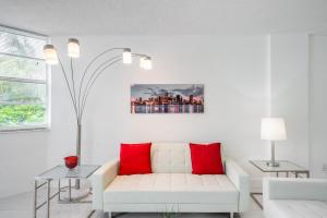 迈阿密海滩Sunny Isles Ocean Reserve Superb Condo Apartments的客厅配有白色沙发和红色枕头。