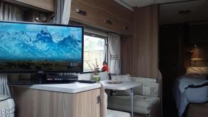 蒂阿瓦穆图Caravan Glamping Accommodation的一台位于rv橱柜上的电视