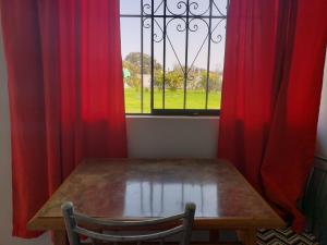 瓦拉尔Los Naturales的窗前的木桌,带红色窗帘