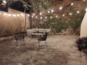 瓜纳华托Casona San Cayetano Suites & Lofts by Lunian的天井配有两把椅子和一张桌子及灯