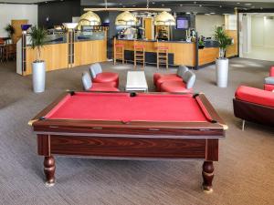 卡迪夫宜必思加迪夫门-国际商业园酒店的一个带椅子的房间和酒吧的台球桌