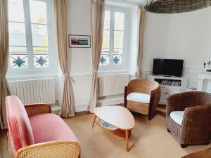 圣马洛Les Sablons - Très Bel Appartement , Lumineux的客厅配有椅子、桌子和电视