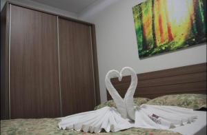 热河市FLAT VEREDAS RIO QUENTE Apto 113的床上用毛巾制成的天鹅