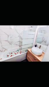 布洛涅-比扬古Cosy Appart Hotel Boulogne -Paris的浴室配有白色浴缸、盥洗盆和浴缸。