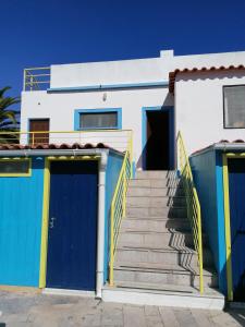 卡拉帕泰拉Casa do Lado的白色的房子,设有蓝色的门和楼梯