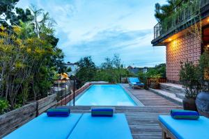 勒吉安Ruang Tekuni的后院游泳池设有木甲板和阳台