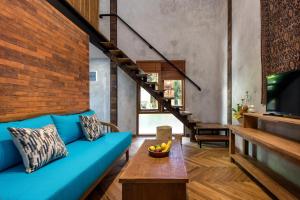 勒吉安Ruang Tekuni的客厅配有蓝色的沙发和木桌