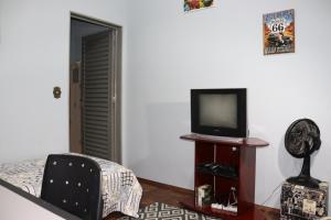 弗朗卡Ecohouse - Próx da Av Brasil的客厅配有电视和椅子