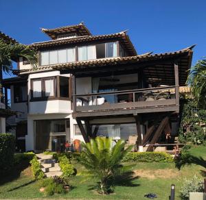 布希奥斯Suite Independente Por do Sol Ferradura的带阳台和棕榈树的大房子