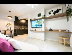 雅典DELUXE ROMANTIC JACUZZI的客厅配有沙发和墙上的电视