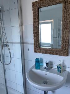 费马恩Hotel & Ferienunterkünfte Hus Seeblick的一间带水槽和镜子的浴室
