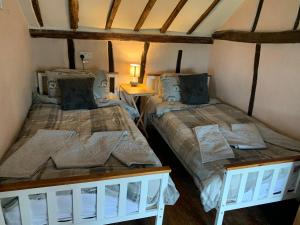 DickleburghMyrtle cottage的一间客房内配有两张床的房间