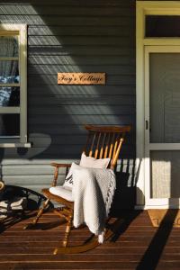 多里戈Fay's Cottage的房屋门廊上的木摇椅