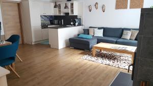 弗拉塔赫Appartementhaus Zraunig的客厅配有蓝色的沙发和桌子