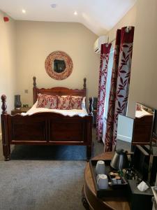 贝克韦尔孔雀酒店的一间卧室配有一张带红色枕头的木床。