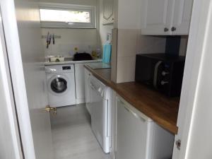 多切斯特Family guest suite in Cheselbourne的白色的小厨房,配有洗衣机和烘干机