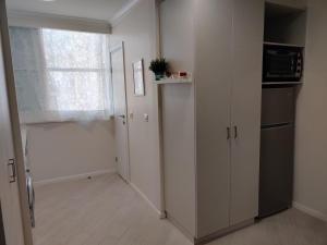 内坦亚Migdal Luxury Suites Netanya J29的客房设有带冰箱和窗户的厨房。