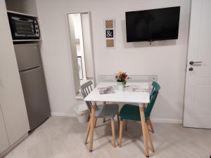 内坦亚Migdal Luxury Suites Netanya J29的小厨房配有白色的桌子和椅子
