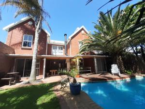 泰布尔维尤Elements Cape Town的一座带游泳池和棕榈树的房子