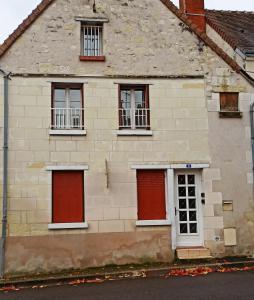 圣艾尼昂A 4 min du Zoo de Beauval La Maison à Partager Ch3 1er étage的一座古老的石头房子,设有红色的门窗