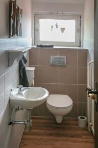 布伦Ferienwohnung Büren的一间带水槽和卫生间的浴室以及窗户。