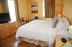 卢嫩堡海盗湾旅馆的卧室配有一张白色大床和电视。