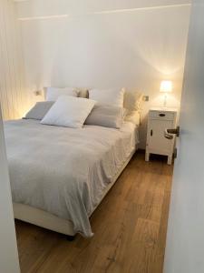 帕索圣佩莱格里诺Appartamento San Pellegrino的卧室配有一张白色床、床头柜和一张四柱床