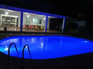 梅里达Jardín Mérida的夜晚在房子前面的一个蓝色泳池