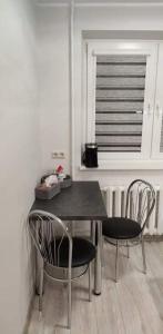希奥利艾Butas miesto centre/ Apartment in the city center的餐桌、两把椅子和窗户