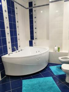 科夫罗夫Palazzo Kovrov的带浴缸和卫生间的浴室以及蓝色瓷砖。