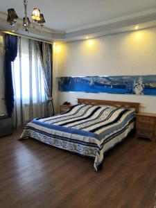 科夫罗夫Palazzo Kovrov的卧室配有一张床,墙上挂着一幅蓝色画作