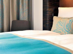 莱比锡莱比锡奥古斯特广场一号汽车旅馆的一间卧室配有蓝色和白色床单
