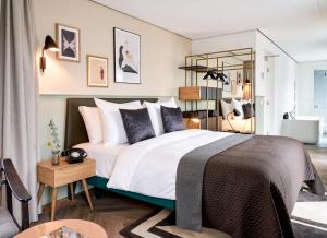 海牙Park Centraal Den Haag, part of Sircle Collection的卧室配有一张带白色床单和枕头的大床。