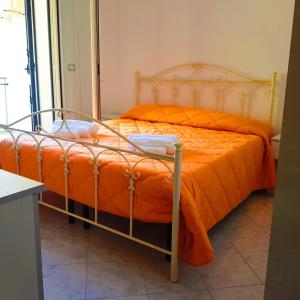 加利波利Case Vacanza IonianTravel Gallipoli的客房内的橙色棉被