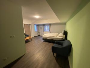 梅明根JG Hotel Memmingen的一间卧室,卧室内配有一张床和一把椅子