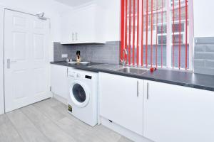 Trent ValeTownhouse @ 543 London Road Stoke的白色的厨房配有洗衣机和水槽