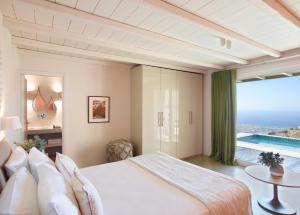 提诺斯埃俄利斯蒂诺斯套房度假屋的一间卧室设有一张大床和一个大窗户