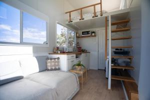 BraidwoodThe Saddle Camp Tiny House, Braidwood的一间带双层床的卧室和一间厨房