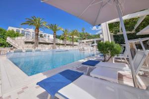 布德瓦地中海酒店及度假村的一个带两把椅子和一把遮阳伞的度假村游泳池